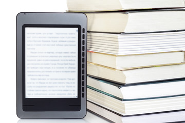 Ebook reader on pile of ordinary books