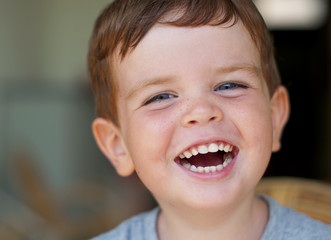 Portrait of a laughing little boy with freckles