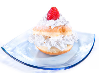 Delicious freshly baked donut with cream and strawberry