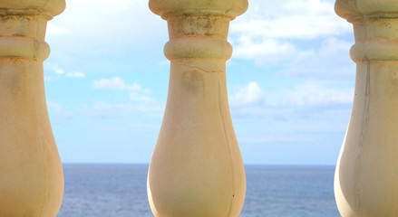 Three pillars, sea and sky in background, shallow dof