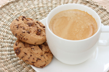 Chocolate chip cookies on saucer with coffee