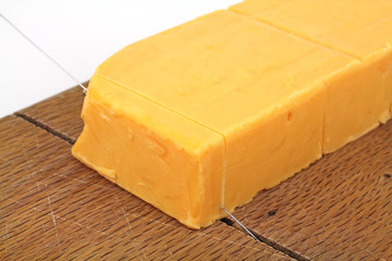Sharp cheddar cheese being cut