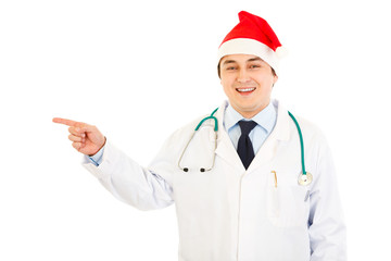 Doctor in hat of Santa Claus pointing  finger in corner