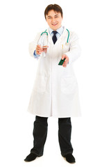 Smiling doctor holding pack of pills and glass of water