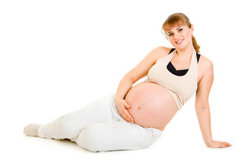 Happy pregnant woman sitting on floor and holding her belly