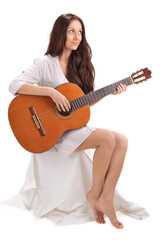 Fototapeta premium Young beautiful brunette lady playing acoustic guitar