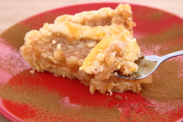 Apple Pie - a slice with cinnamon being eaten with a fork