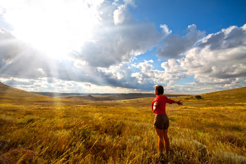 Fototapeta premium Greeting the sun, women on meadow and cloudy sky