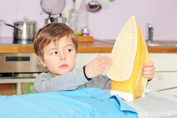 Kind greift an Bügeleisen