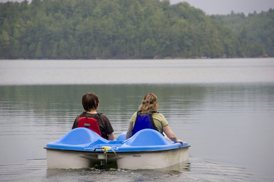 Mother and son pladdleboating on a lake