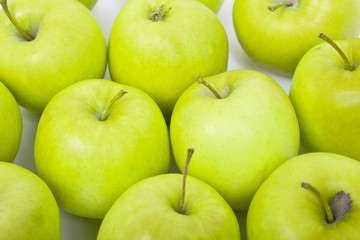Green and yellow apples on a white baclground