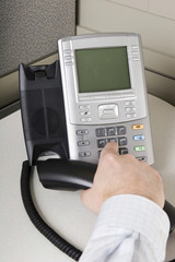 Office worker placing a call on an IP phone