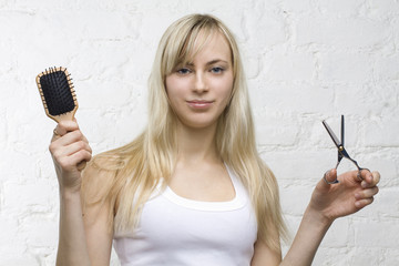 Smiling woman hairdresser with professional tools - comb and sci