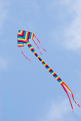 Colorful kite flying in blue sky.