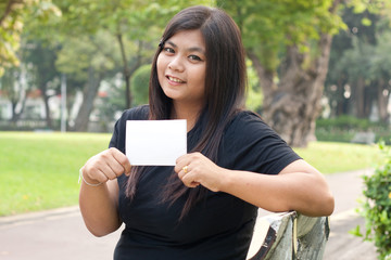 Women in the garden and holding a white card..