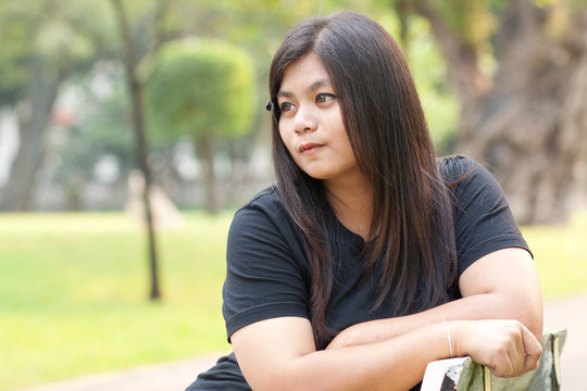 Woman in garden looking absent-minded.