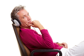 Senior im Stuhl mit Kopfhörern