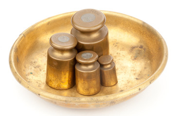 Three brass old weights on a golden plate