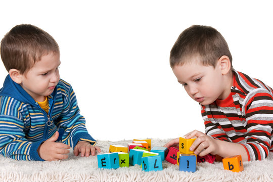 Brothers playing blocks on the carpet
