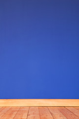 Renovierter Holzfußboden mit tiefblaublau gestrichener Wand