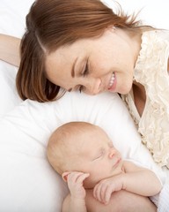 Young Mother Watching Her Newborn Son Sleep