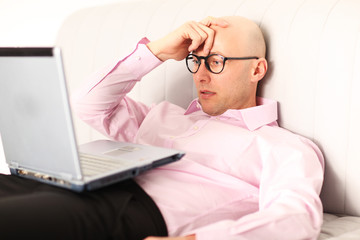 mit Notebook am Sofa Zuhause