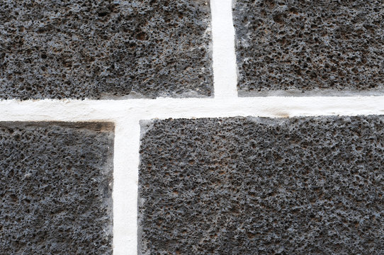 Dark volcanic bricks with white cement joints, pattern
