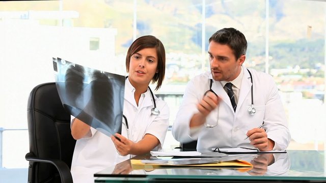 Two doctors taking notes about a scan