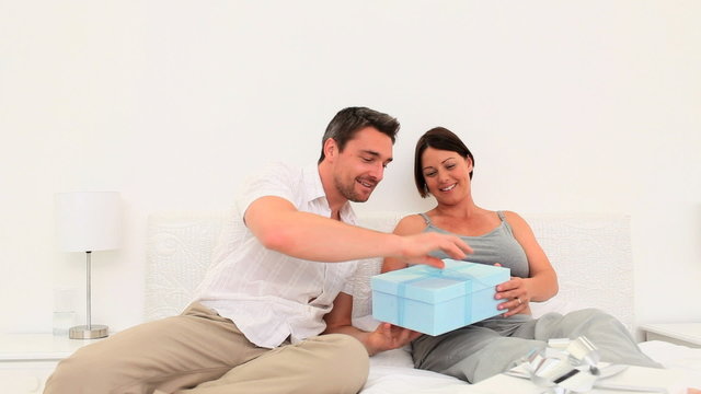 Man giving a gift to his pregnant wife