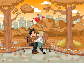 Young  couple kissing at the park bench on autumn