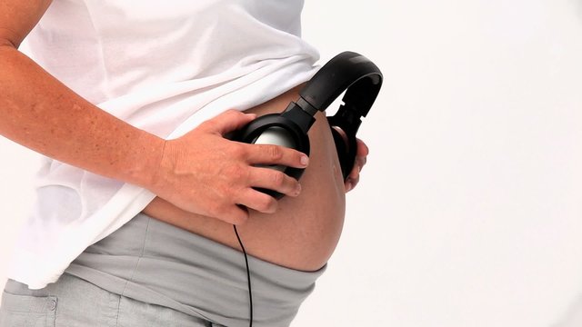 Pregnant woman letting her future baby listening to music
