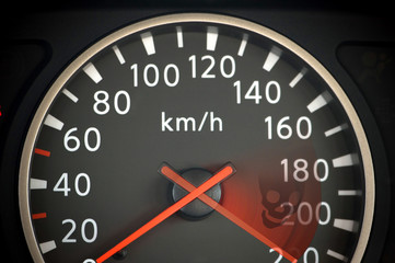 Close up of car speedometer with red arrow