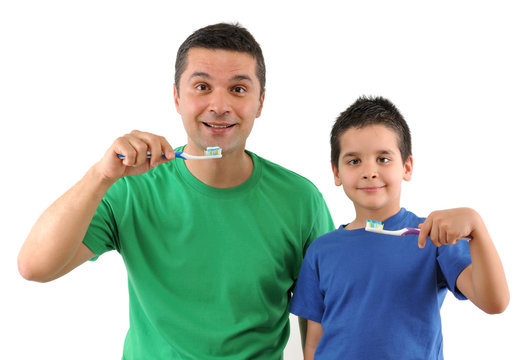 Cute boy and his father brushing teeth isolated on white.