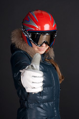 A girl in ski clothing raises a big thumbs up