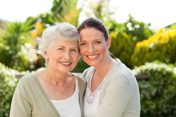 Mother with her daughter looking at the camera in the garden