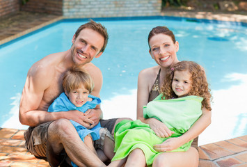 Fototapeta na wymiar Portrait of a happy family beside the swimming pool