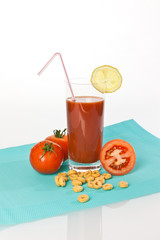 Tomatensaft im Glas mit Tomaten und Zitronen und Cornflakes