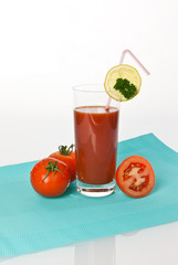 Tomatensaft im Glas mit Tomaten und Zitronen