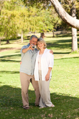 Elderly couple taking a photo of themselves in the park