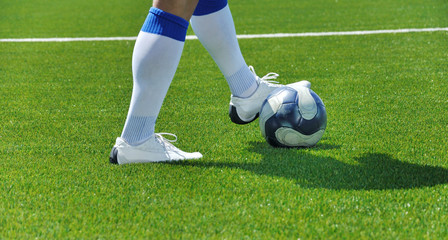 Soccer player and ball on the grass field