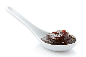 Plum jam in a white spoon