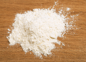 Fototapeta na wymiar Wheat flour heap on a wooden background