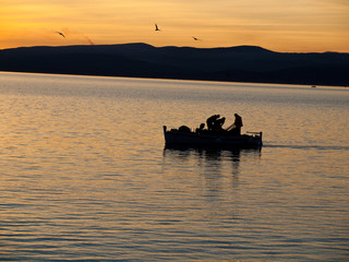 Fisher mans on sea in sunset