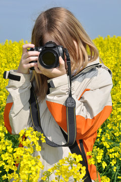 girl taking photos in rapeseed field