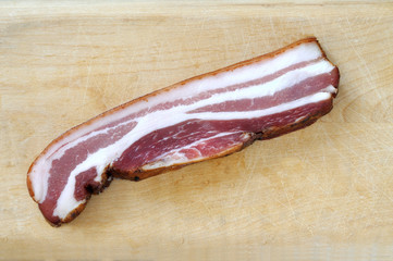Pancetta affumicata su tagliere di legno