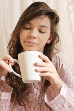 Mädchen mit Kaffeebecher im Bett