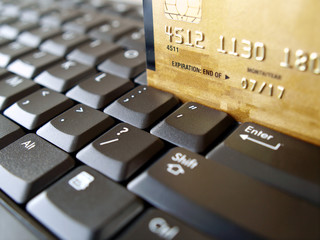 Golden credit card on computer keyboard.