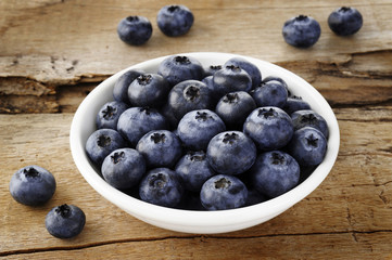blueberry in bowl on wood background