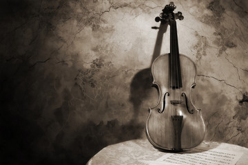 Old italian violin on a wall background