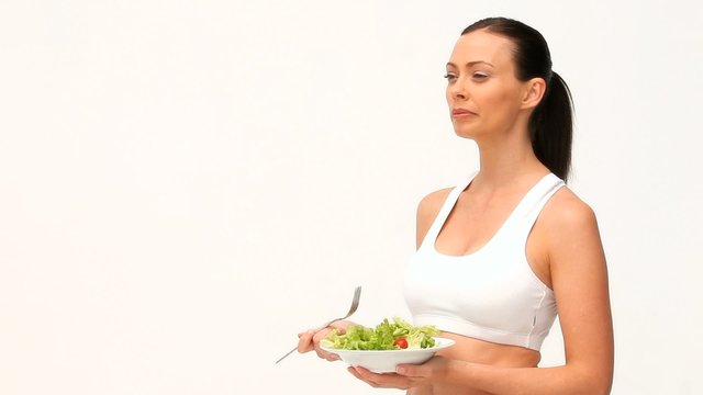 Brown-haired woman eating a salad